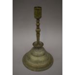 An antique Islamic brass candlestick. 34 cm high.