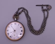 A Victorian pocket watch with a silver chain. 4.75 cm diameter.
