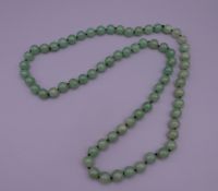 A string of jade beads. 89 cm long.