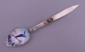 An 800 silver and enamel spoon, the bowl decorated with a ski jumper, the handle formed as a ski.