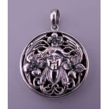 A sterling silver Art Nouveau style pendant. 3 cm diameter.