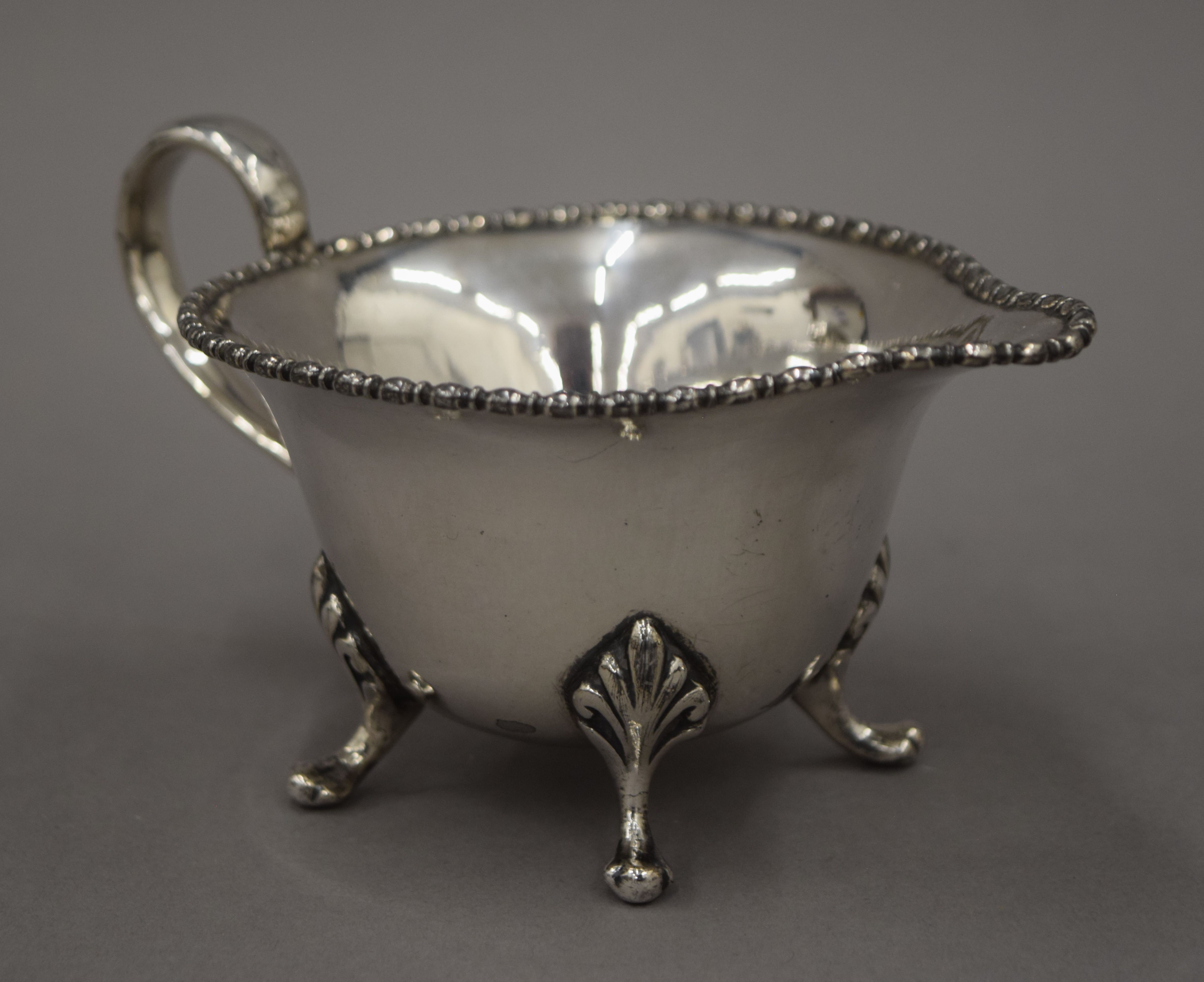 A three-piece silver plated tea set and a three-piece porcelain and silver overlaid tea set and an - Image 9 of 10