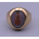 An unmarked 9 ct gold signet ring with carved seal crest (crest matches with following lot).