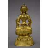 An antique gilt bronze model of Buddha. 17 cm high.