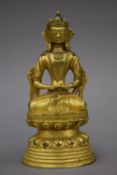 An antique gilt bronze model of Buddha. 17 cm high.