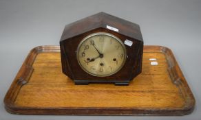 An early 20th century oak mantle clock and an oak tray. The former 26 cm wide.