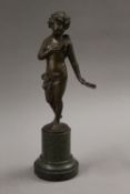 A bronze model of a girl holding a tambourine, indistinctly signed. 28 cm high.