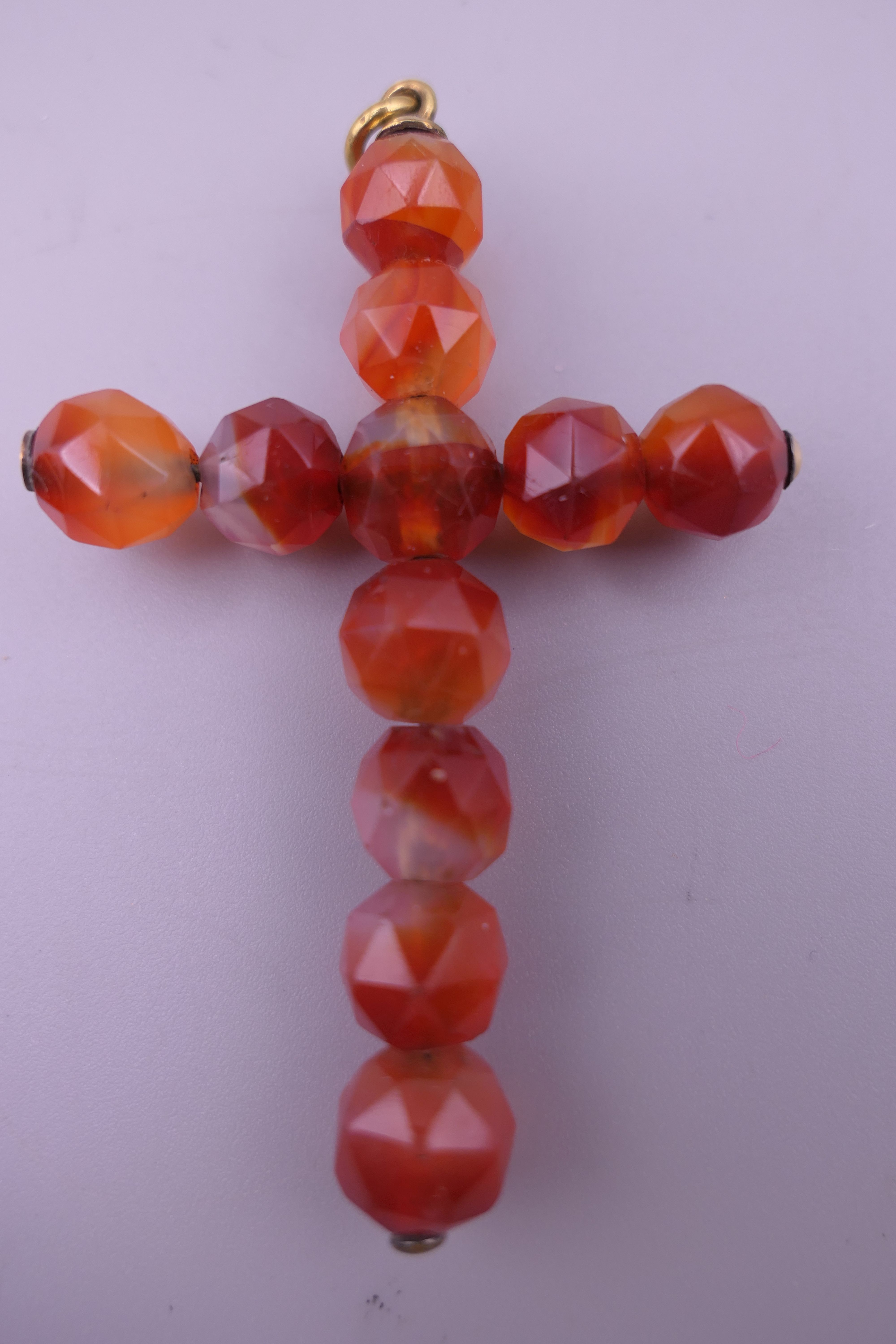 An antique faceted carnelian crucifix pendant in an arched case. 6.5 cm high. - Image 2 of 6