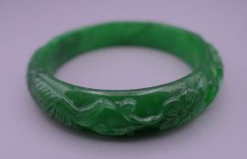 An apple green jade carved bangle. 6 cm interior diameter.