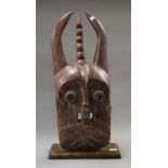 A large 19th century wooden tribal mask inset with glass trader beads from Mali. 75 cm high.