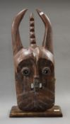 A large 19th century wooden tribal mask inset with glass trader beads from Mali. 75 cm high.