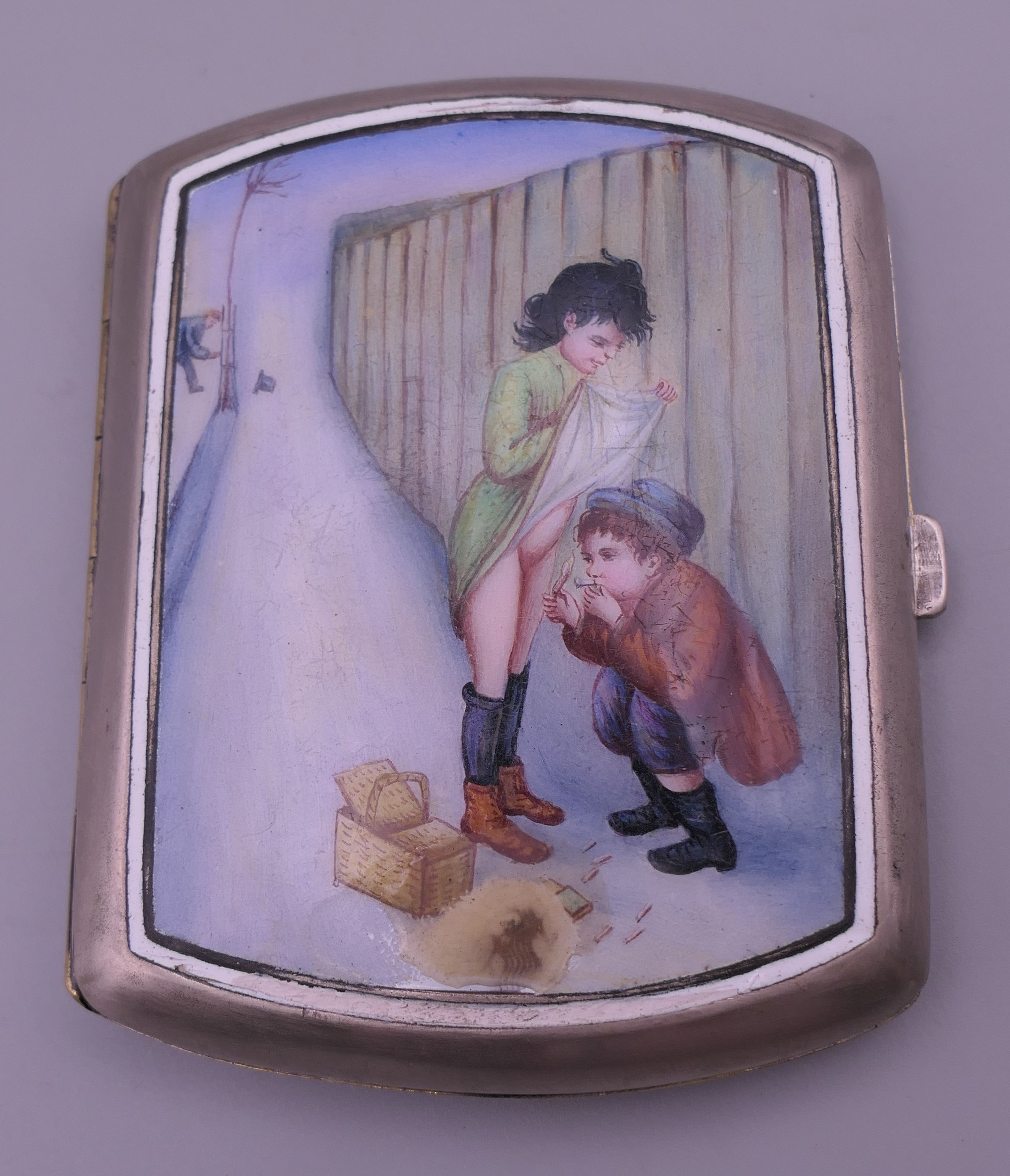A late 19th/early 20th century silver plated cigarette case with amusing enamel decoration. 7.