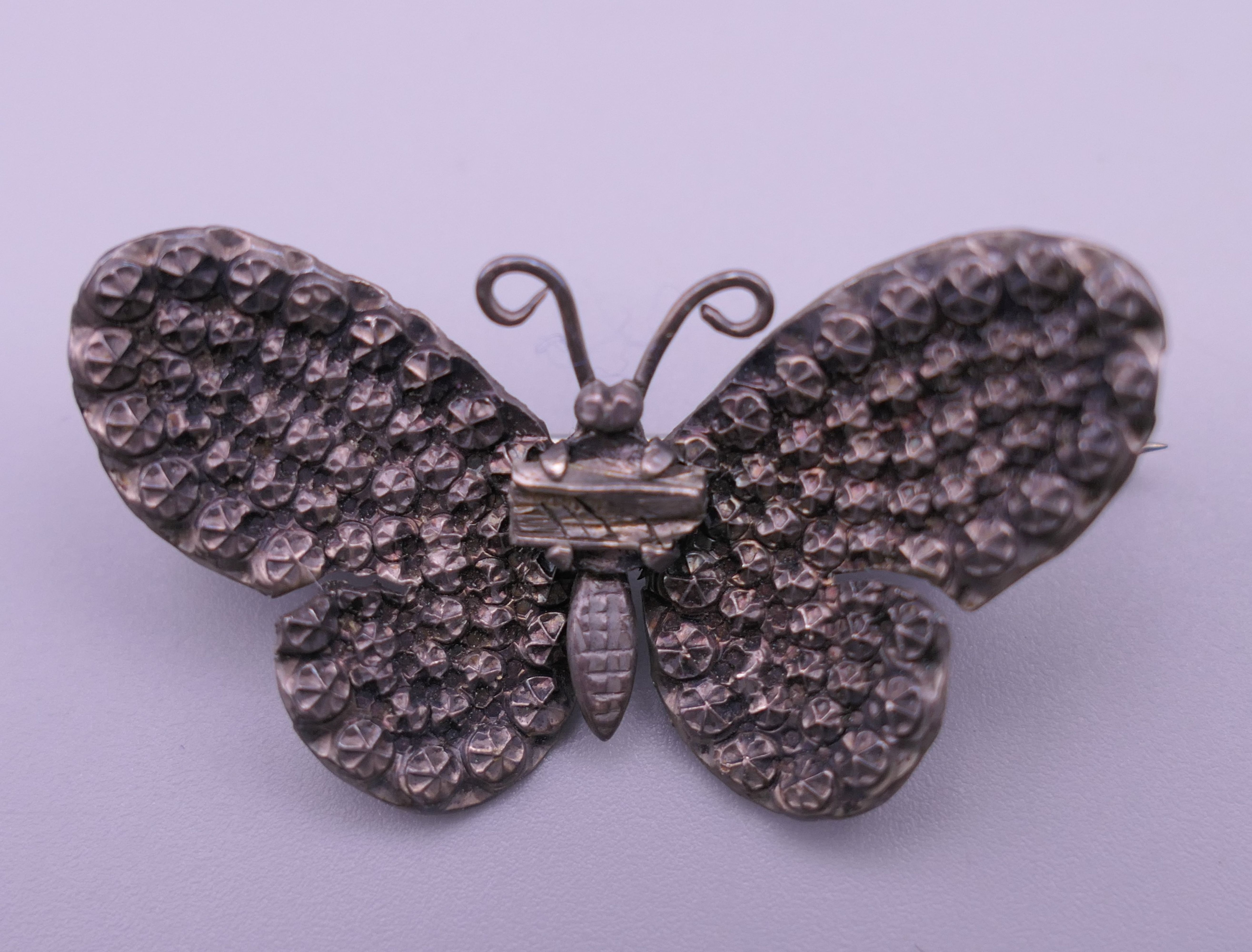 A silver locket, a white metal (silver) horseshoe brooch and a butterfly brooch. - Image 2 of 9