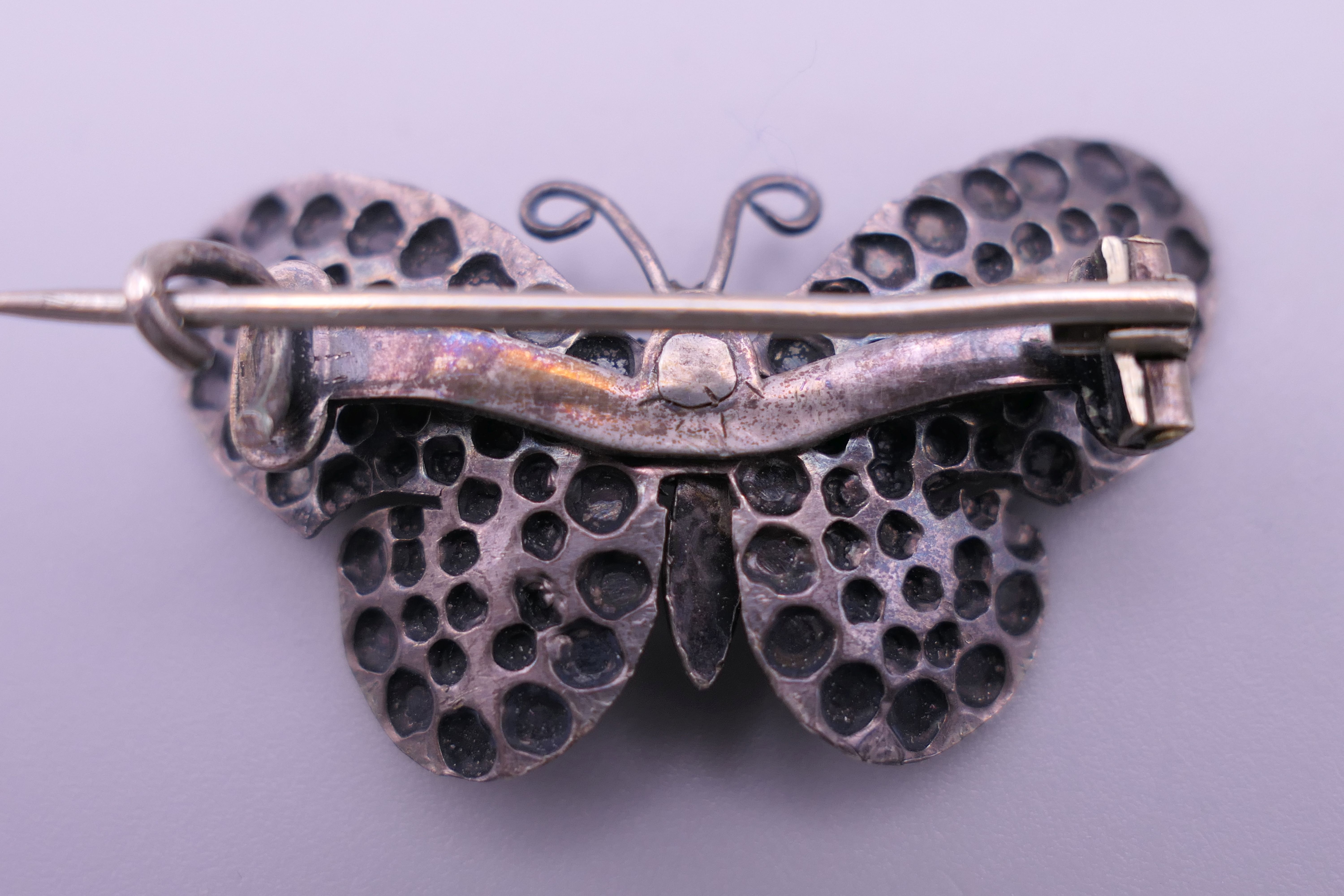A silver locket, a white metal (silver) horseshoe brooch and a butterfly brooch. - Image 3 of 9