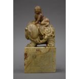 A finely carved Chinese soapstone seal carved with a boy and an elephant. 19 cm high.