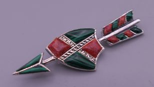 A silver malachite and coral arrow brooch. 5.5 cm long.