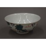 A 19th century Chinese porcelain bowl decorated with dogs of fo amongst clouds,
