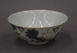A 19th century Chinese porcelain bowl decorated with dogs of fo amongst clouds,
