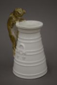A Copeland porcelain cream jug, the handle formed as a cat. 14.5 cm high.