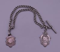 A silver watch chain and two silver fobs. 27 cm long. 56.1 grammes.