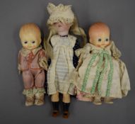 A 19th century and later bisque headed doll and two other dolls. The former 23 cm high.