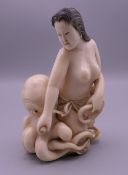 A 19th century Japanese carved ivory okimono formed as a woman and an octopus. 10.5 cm high.