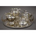 A three-piece silver plated tea set and a three-piece porcelain and silver overlaid tea set and an