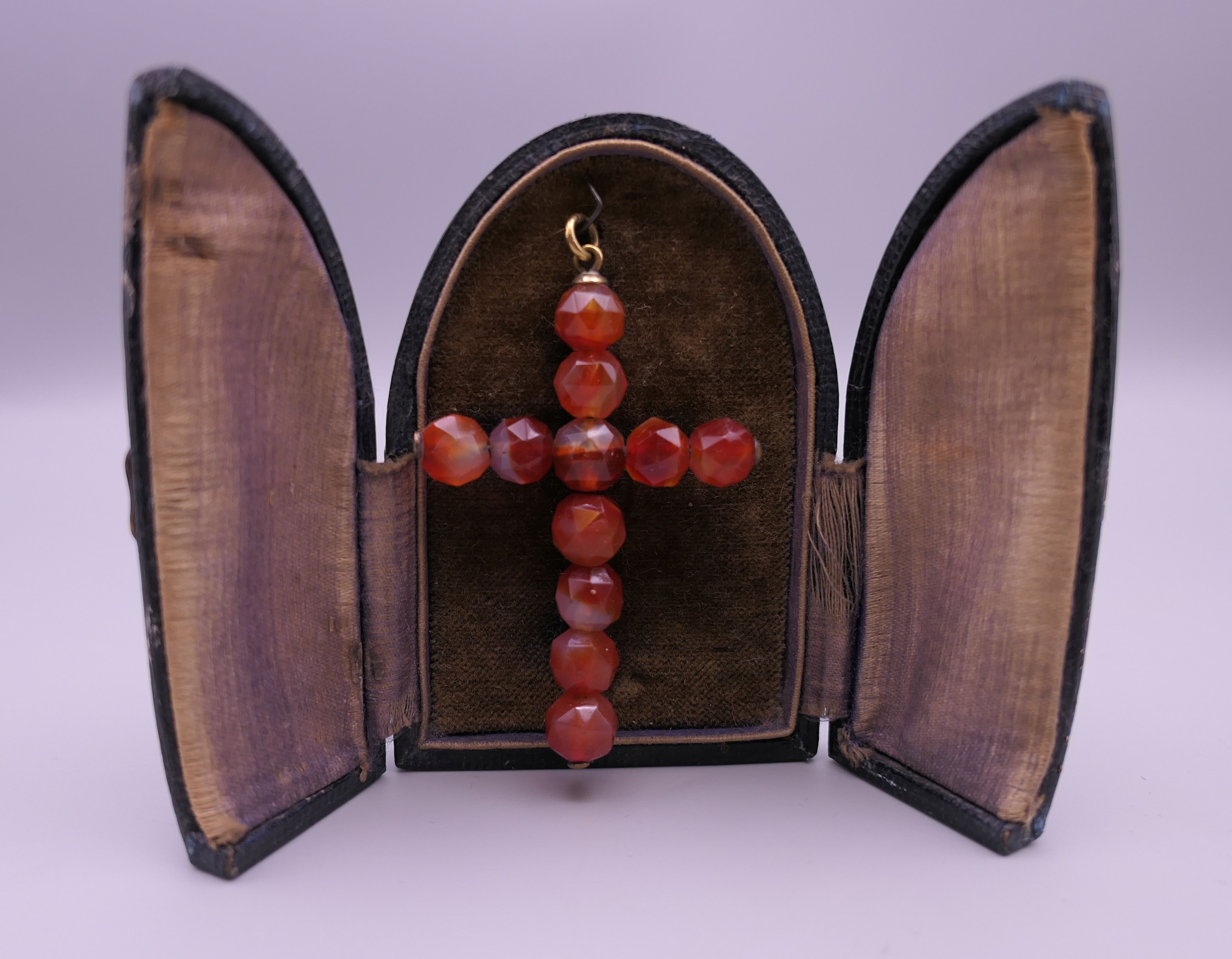 An antique faceted carnelian crucifix pendant in an arched case. 6.5 cm high.