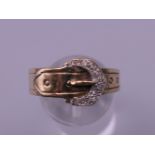 A 9 ct gold diamond chip set buckle ring. Ring size U/V. 4.2 grammes total weight.