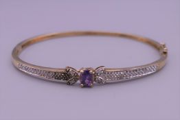 A 9 ct gold diamond and amethyst bangle. 6.5 cm wide. 7.6 grammes total weight.