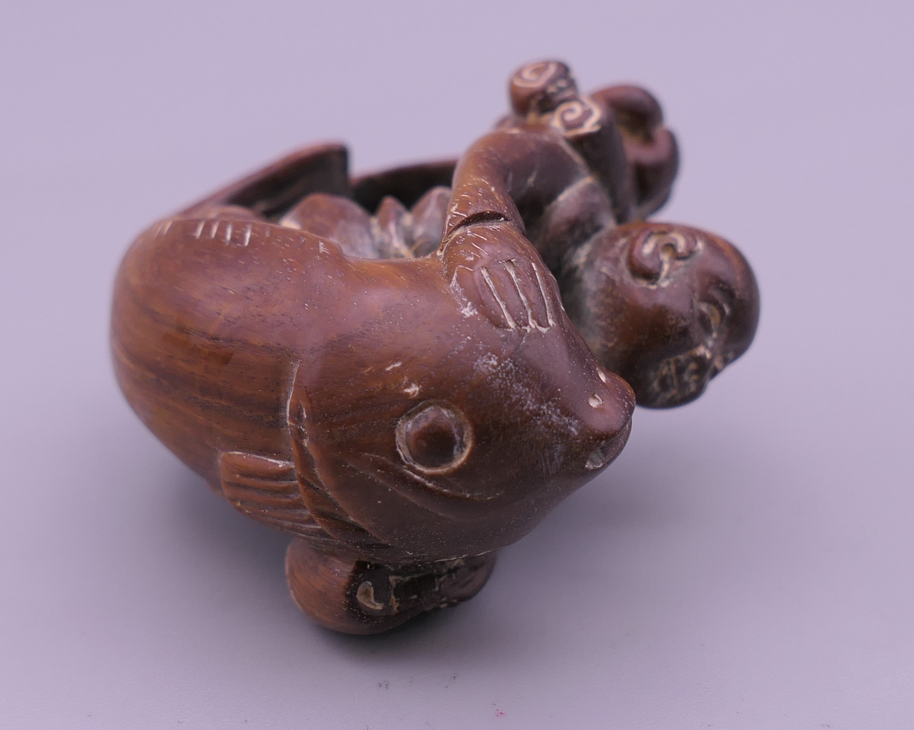 An Oriental carving formed as a man with a fish. 4.5 cm long. - Image 3 of 4