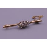 A 9 ct gold three stone diamond bar brooch. 4.5 cm long. 3.7 grammes total weight.