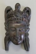 An Eastern carved wooden mask. 30 cm high.