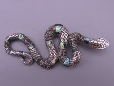 A silver and abalone snake form pendant. 8.5 cm long.