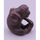 A wooden netsuke formed as a monkey. 4.5 cm high.