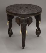 A late 19th/early 20th century Eastern carved wooden elephant table. 60 cm diameter.