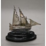 A Maltese silver model of a sailing boat on an oval wooden base. 10 cm high.