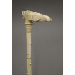 A 19th century carved ivory walking stick with elephant and lion mask handle. 90 cm long.