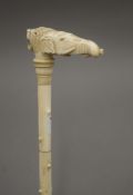 A 19th century carved ivory walking stick with elephant and lion mask handle. 90 cm long.