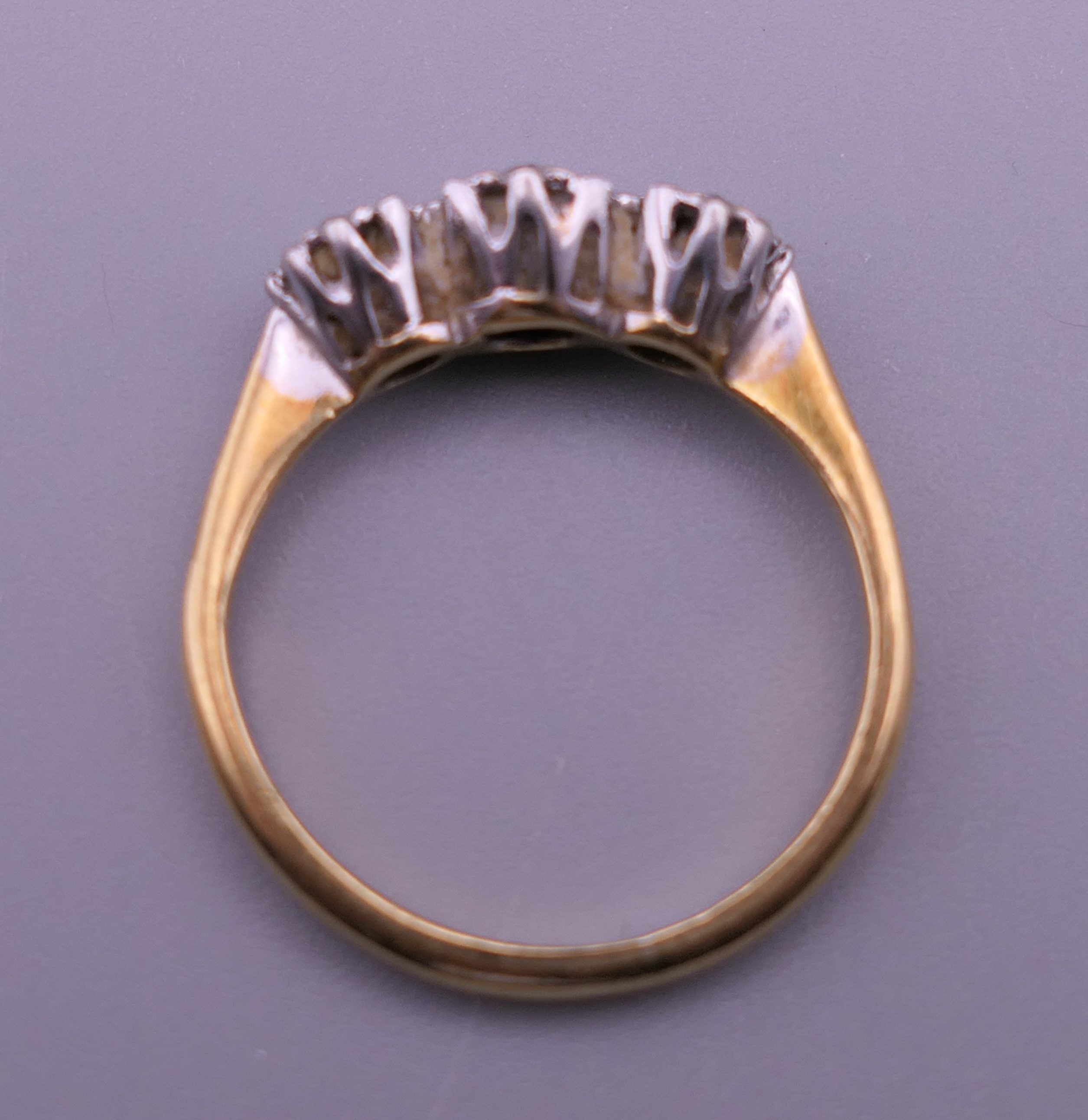 An 18 ct gold and platinum three stone diamond ring. Ring size J/K. 2.3 grammes total weight. - Image 4 of 6