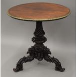 A 19th century brass mounted carved mahogany tripod table. 72 cm diameter.