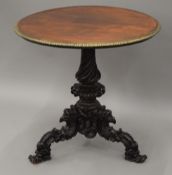 A 19th century brass mounted carved mahogany tripod table. 72 cm diameter.