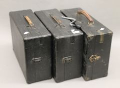 Three vintage portable gramophones.