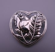 A silver heart and bird formed brooch. 3.25 cm wide.