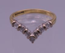 An 18 ct gold diamond wishbone ring. Ring size N/O. 2.9 grammes total weight.