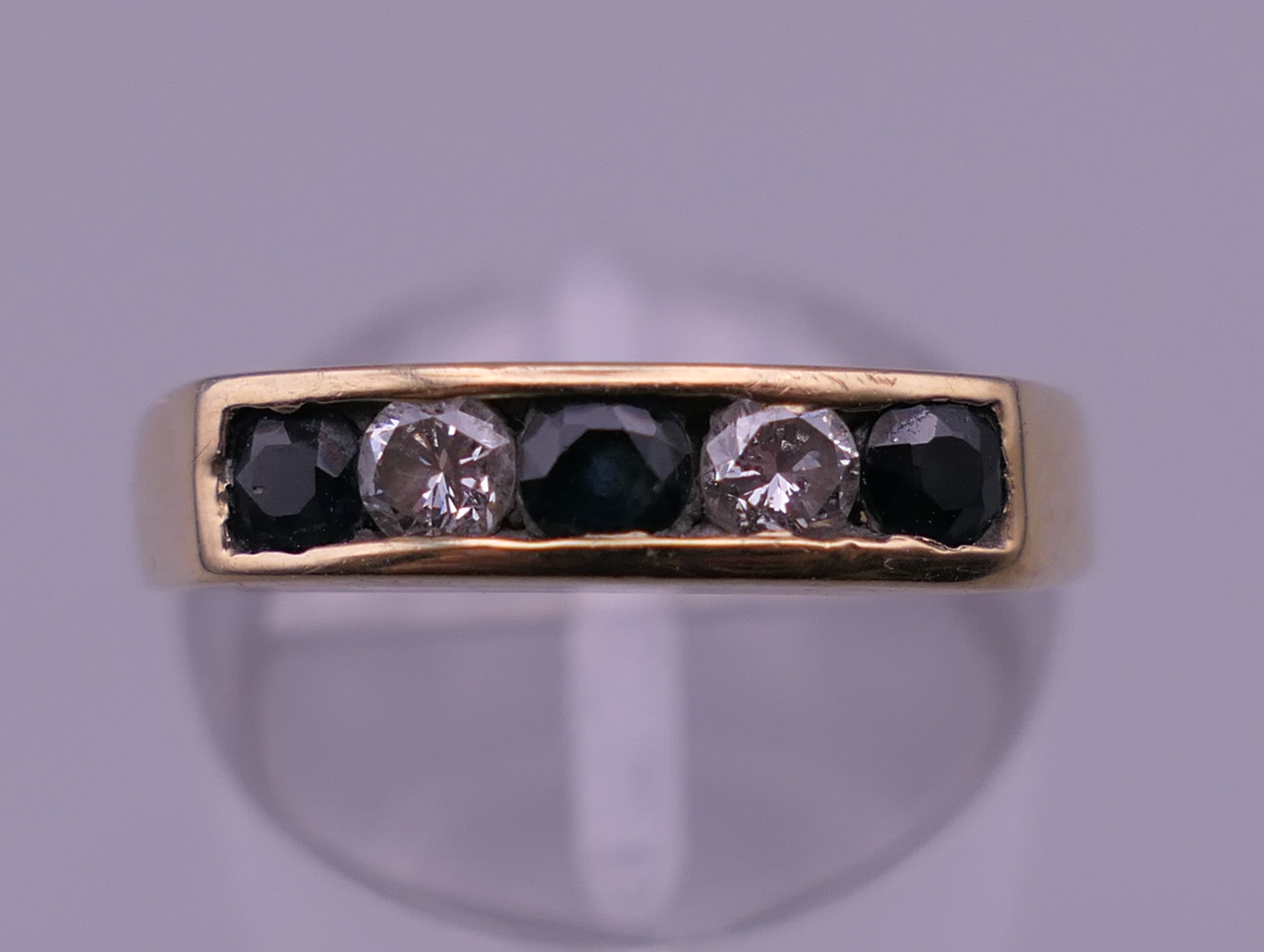 A 9 ct gold diamond and sapphire ring. Ring size N. 2.9 grammes total weight.