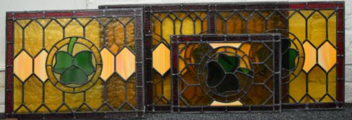 Five pieces of stained leaded glass, each decorated with a clover. The largest 85 cm long.