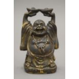 A Chinese bronze model of Buddha, possibly a scroll weight. 10 cm high.