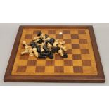 A vintage carved wooden chess set and a chess board. The kings 8 cm high.