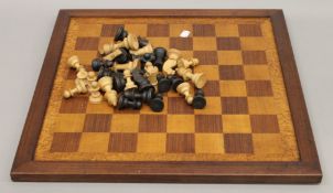 A vintage carved wooden chess set and a chess board. The kings 8 cm high.